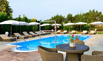 Außenpool an sonnigem Tag mit Sonnenschirmen