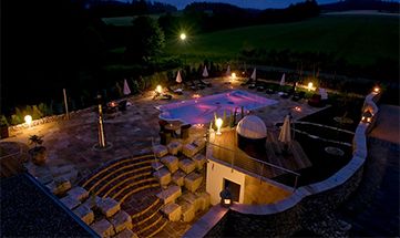 Beleuchteter Garten mit Pool am Abend