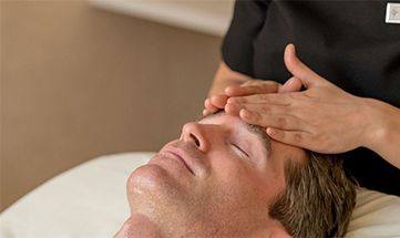 Mann genießt Gesichtsmassage