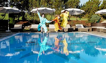 Freundinnen springen gemeinsam in den Pool