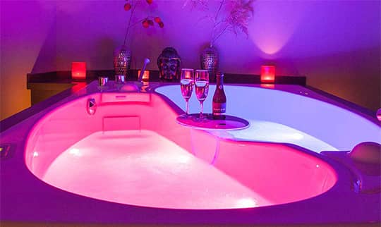 Rosa beleuchteter Raum mit einer Paarbadewanne