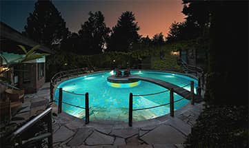 Beleuchteter Außenpool am Abend