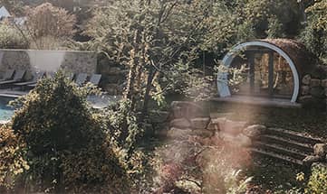 Blick auf den Garten mit Liegen neben dem Außenpool