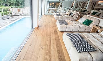 Ruheraum mit Glasfasse und Blick auf den Außenpool