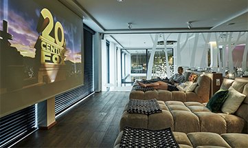 Paar in weißen Bademänteln schaut Film auf Leinwand im Spa Kino