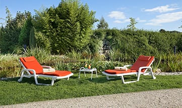 Zwei rot-weiße Liegen im Garten am Tag