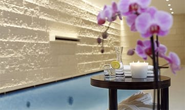 Kerzen und Blumen neben Wasser