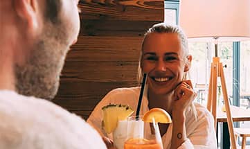 Paar in weißen Bademänteln genießt erfrischende Drinks